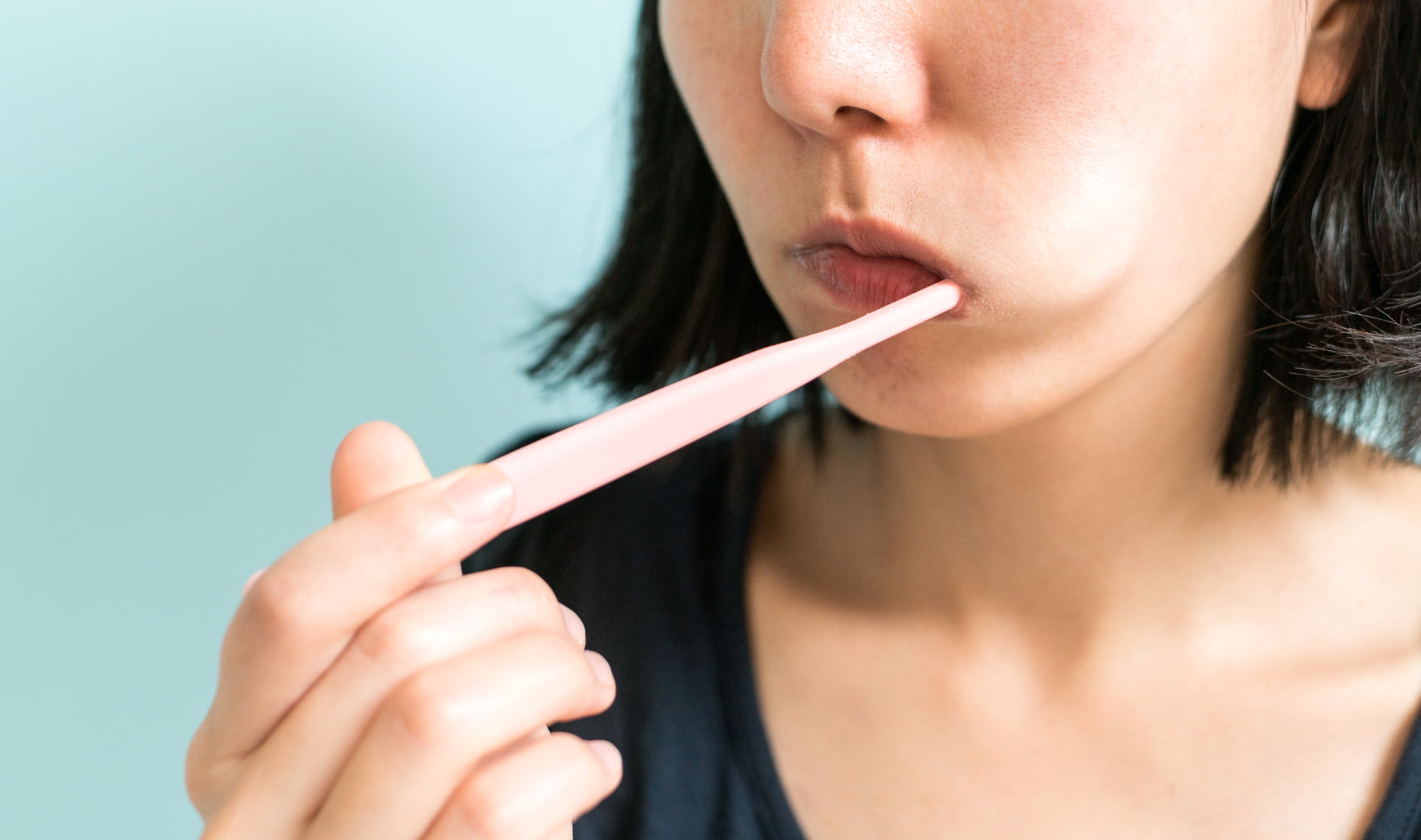 磨きにくさを感じながら歯磨きするマウスピース矯正中の女性