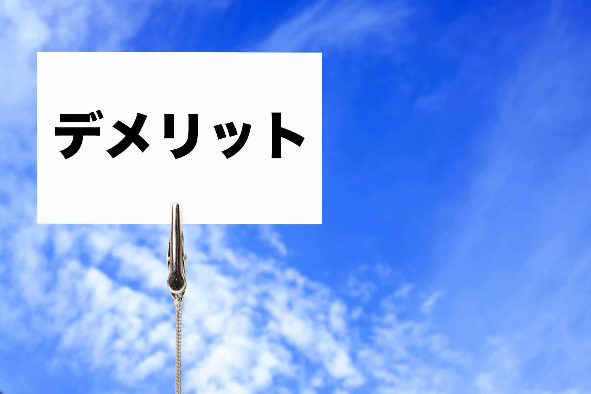 青空の背景にデメリットと書かれたカード
