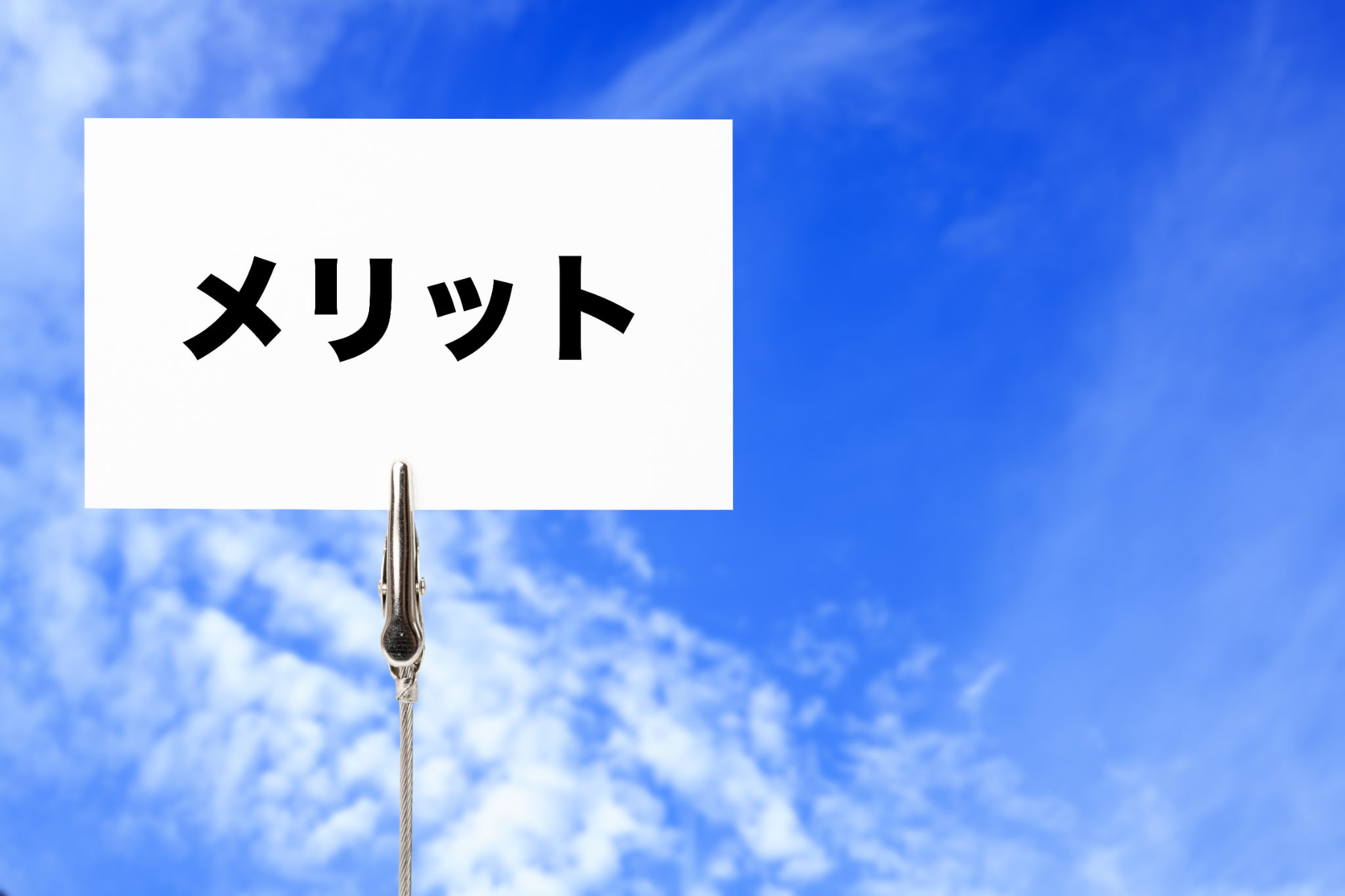 青空の背景にメリットと書かれたカード